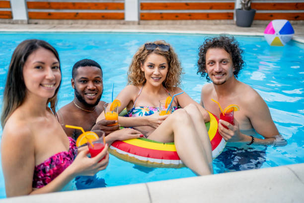 istock Young friends in swimming pool 2206086309