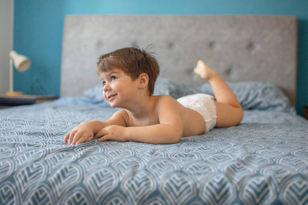 Little boy in diaper lying on the bed