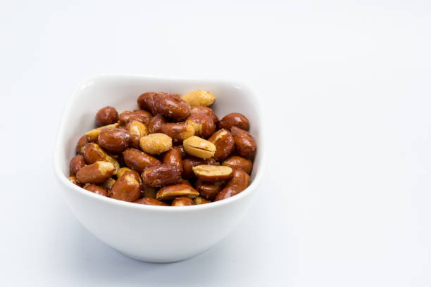 istock Dish of fried peanuts with skin and salted with white background 2206088797