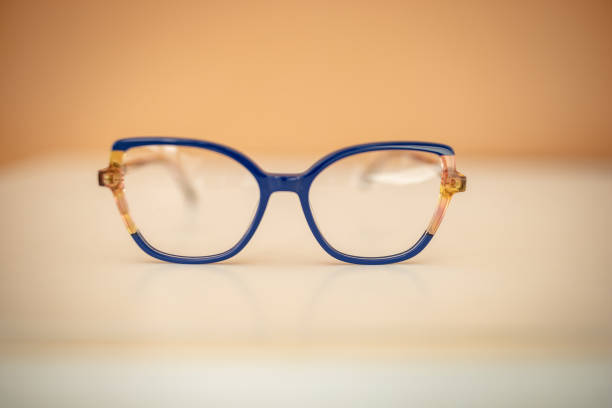 Stylish eyeglasses feature vibrant blue frames with subtle detailing, placed on a light surface. Their modern design makes them a perfect accessory for fashionable looks.