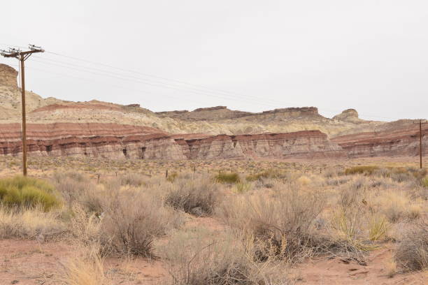 istock Cloudy Desert Landscape with Layered Rock Formations and Power Lines 2206090924