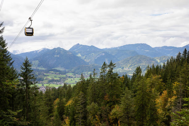 Cable car going through the thick fog and above the forrest of the Austrian Alps during Autumn