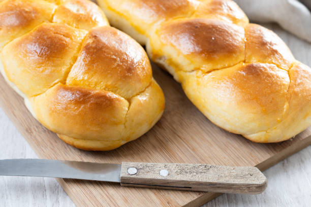 istock Traditional Easter braided bread. Tsoureki braid on white wooden table 2206091373