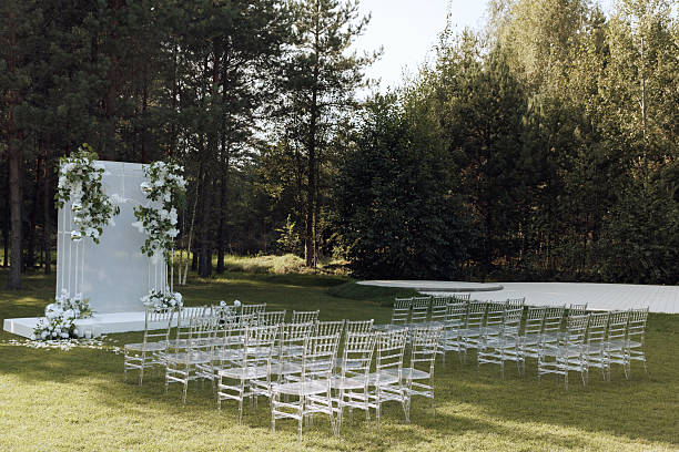 istock Elegant outdoor wedding ceremony with floral arch and transparent chairs. 2206091663