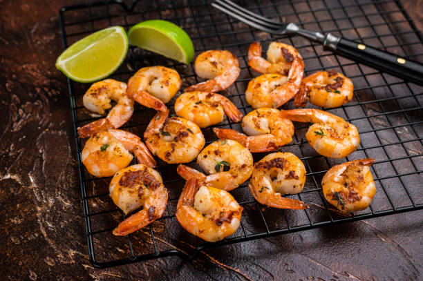 istock Grilled Shrimps Prawns with garlic on a rack. Brown background. Top view 2206095261
