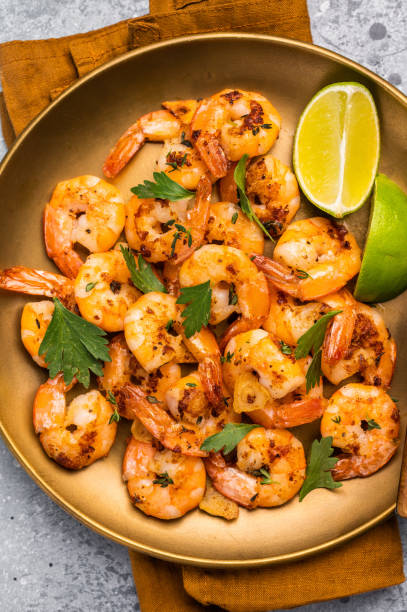 istock BBQ dinner with roast Shrimps Prawns in a plate. Gray background. Top view 2206095270