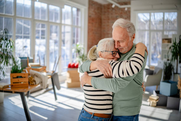 istock Senior couple enjoying their new home while surrounded by boxes and welcoming decor 2206095871