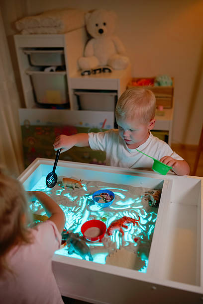 istock Preschoolers playing on sensory box. 2206098482