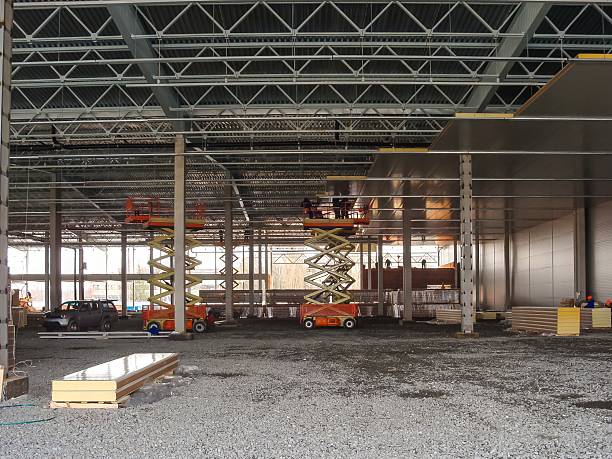 istock Workers are using scissor lifts to install ceiling panels inside a new industrial warehouse. 2206099611