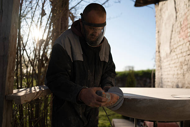 istock Worker Polishing Stone Surface Outdoors in Natural Lighting 2206101316