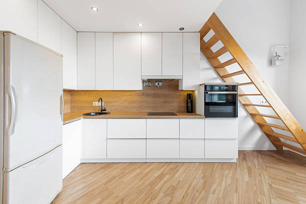 istock Modern Home Minimalist Kitchen Interior with Wooden Staircase and Bright Lighting 2206101331