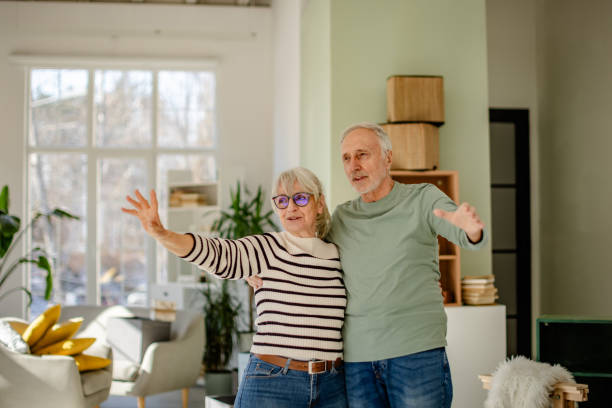 istock Senior couple expresses joy while decorating their new home in a bright, open living space 2206103426