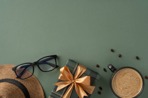 istock Gift box with bow, coffee cup, glasses, and hat on a green background 2206106742