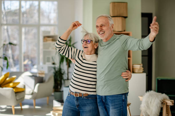 istock Senior couple joyfully celebrating their new home while unpacking and decorating together 2206106962