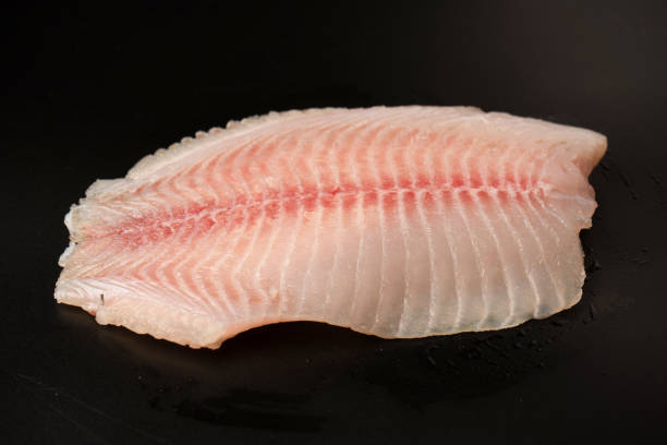 istock Fresh tilapia fillet on black background, top view. 2206107593