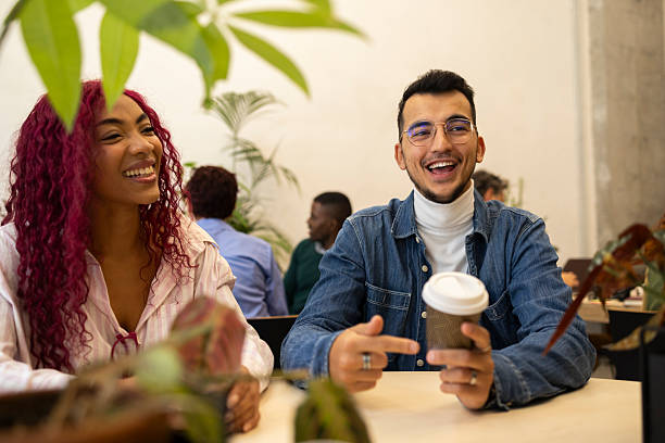 istock Coworkers enjoying coffee break and sharing laughs in modern office 2206109428