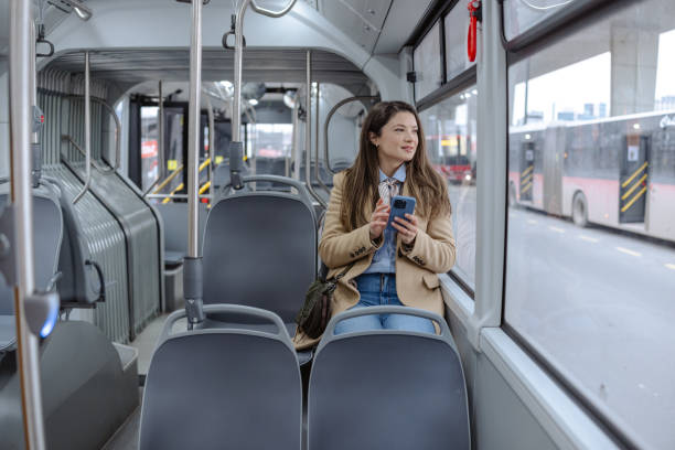 istock Woman sitting on public transport using her smartphone 2206110867