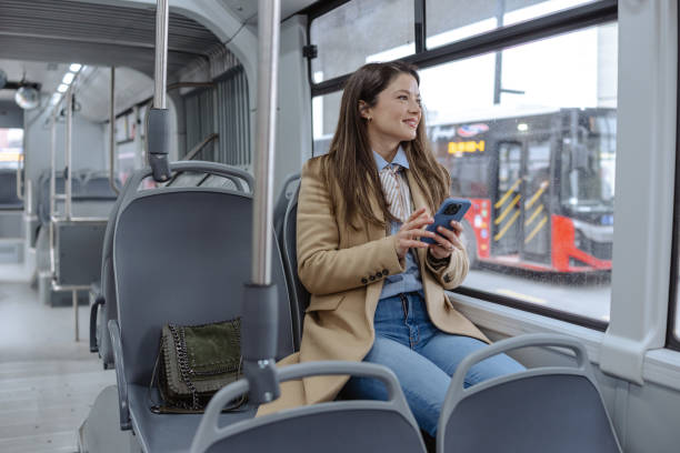 istock Woman Using Smartphone While Traveling Alone on a Public City Bus 2206110873