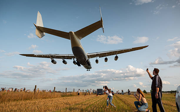 Rear three quarter view of huge six-engined Mriya airplane above a crowd of aviation ethusiasts. Hostomel, Ukraine - August 22 2021.