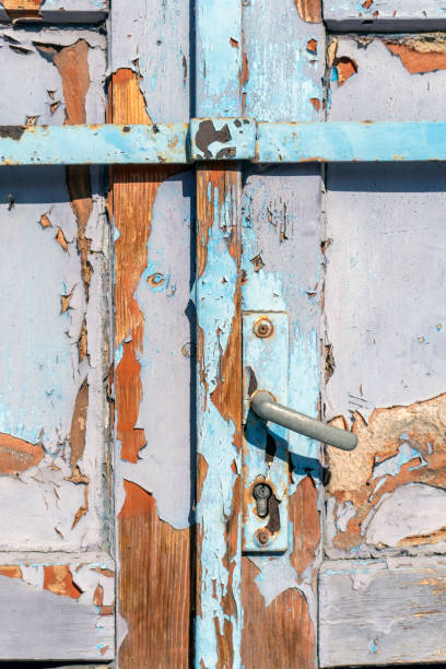 istock Weathered blue door showcases peeling paint and rustic charm in an old building during bright daylight 2206113939