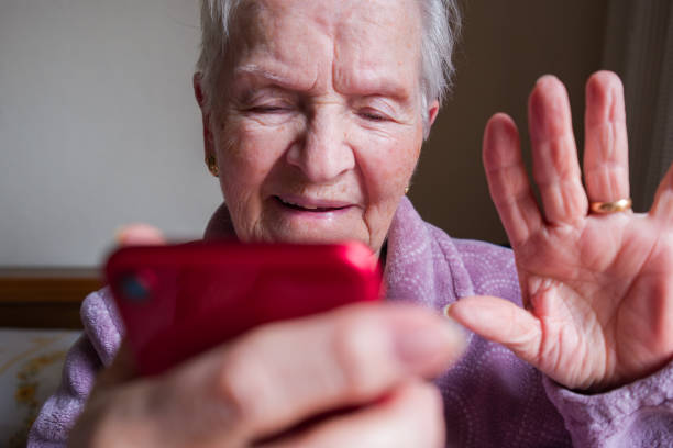 istock Elderly woman making a video call and waving 2206117180