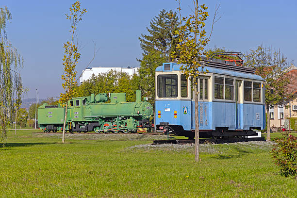 Slavonski Brod, Croatia - October 22, 2024: Steam Machine Locomotive and Old Tram at Tourist Industrial Park Djuro Djakovic Open Air Free Museum.
