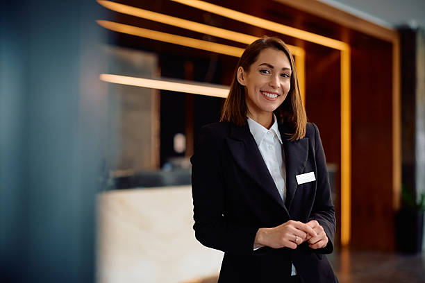 istock Happy female concierge in hotel hallway looking at camera. 2206124119