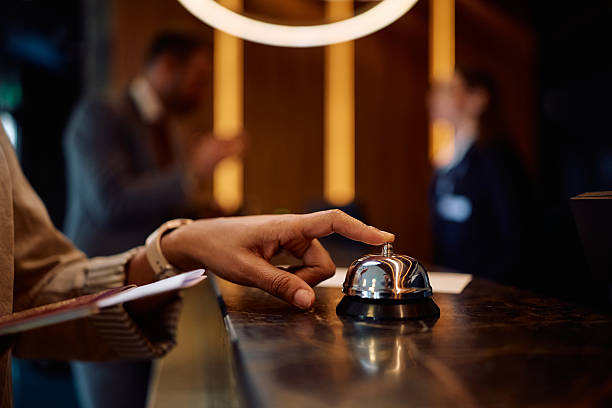 istock Close up of woman using service bell at hotel reception. 2206124220