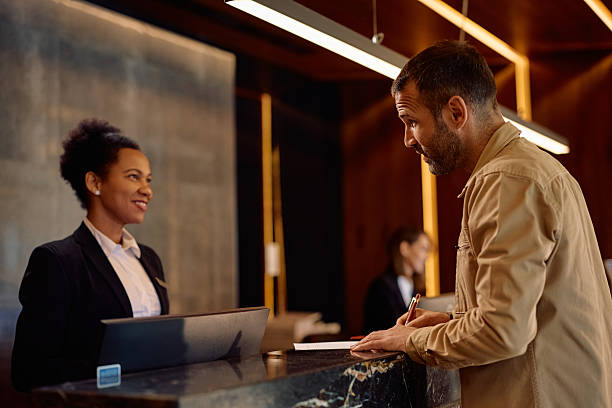 istock Hotel guest signing paperwork at reception desk. 2206124245