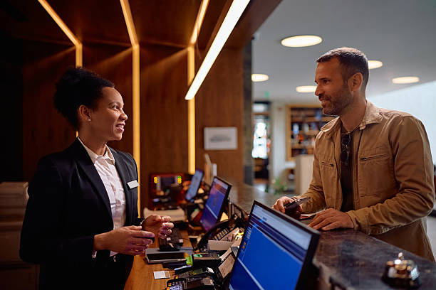 istock Happy guest talking to black female receptionist while checking in at the hotel. 2206124292