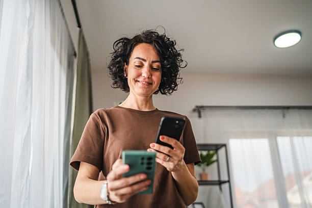 istock woman hold two mobile phones, use wireless connection technology 2206126289