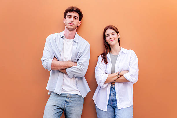 istock young couple looking at camera with arms crossed 2206127414