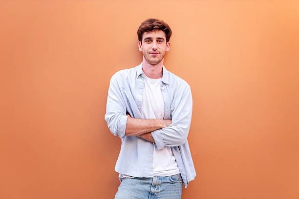 istock smiling young man standing with arms crossed 2206127418