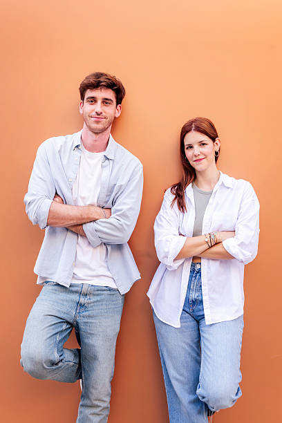 istock young couple looking at camera with arms crossed 2206127419