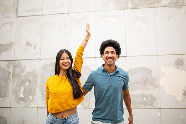 istock cheerful young couple with hand in air 2206127459