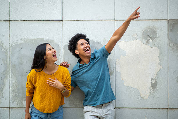 istock happy young couple pointing finger 2206127492