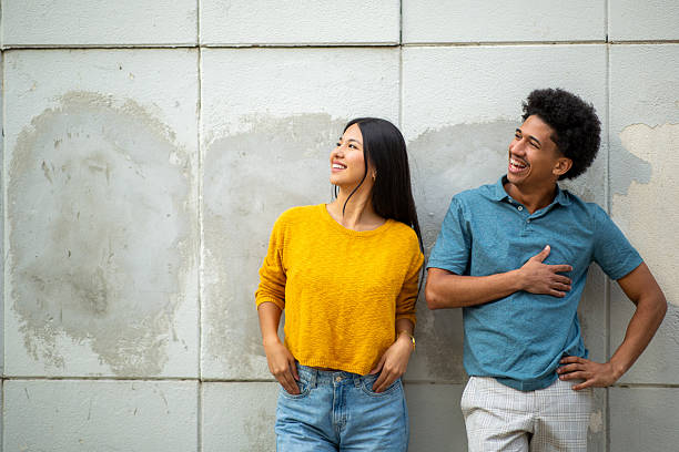 istock happy young couple by wall and looking away 2206127494