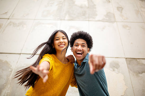 istock happy young couple pointing finger 2206127497