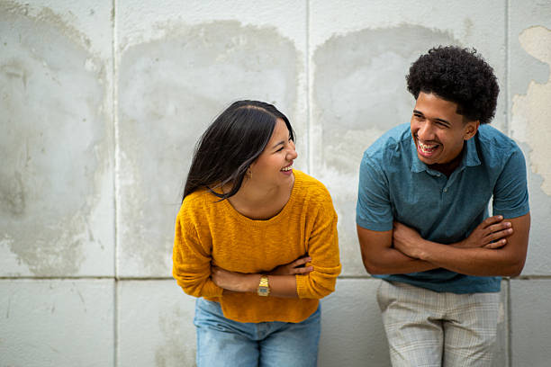 istock laughing young couple by wall 2206127499
