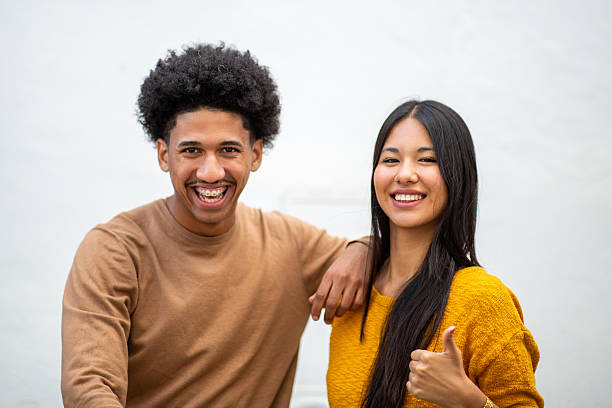 istock smiling young couple posing by white wall 2206127500