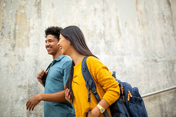 istock happy students with bag walking on street 2206127502