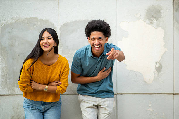 istock happy young couple laughing by wall 2206127503