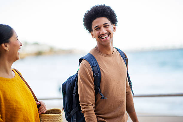 istock two happy friends walking by seaside with bag 2206127507