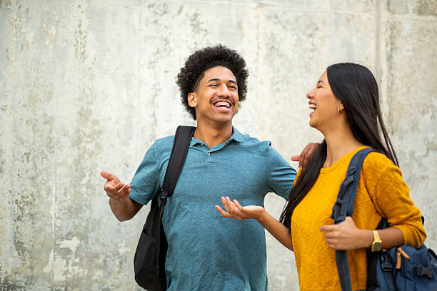 happy male and female students with bag
