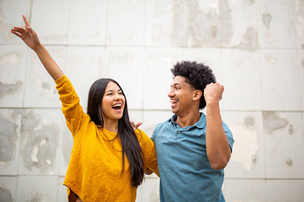 istock happy young couple with arms raised 2206127515
