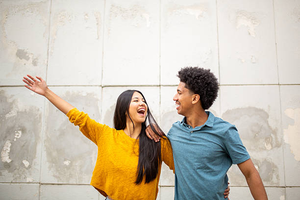 istock smiling young couple standing by wall 2206127538