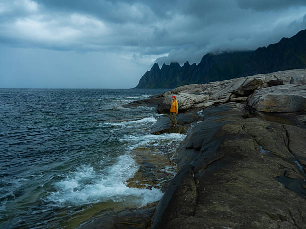 Serene man exploring the seaside Lofoten Island in stormy weather. Shot on medium format camera with immense quality of details
