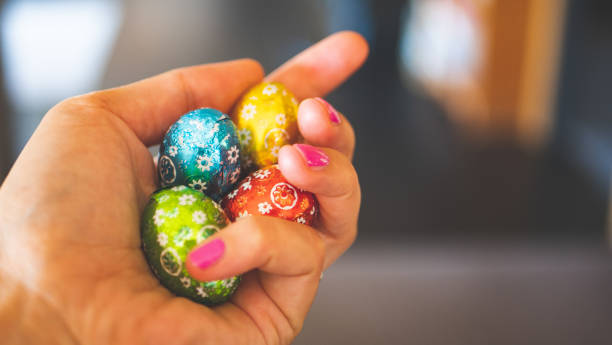 istock Human hands holding easter chocolate eggs colourful wrapped tasty chocolates 2206132866