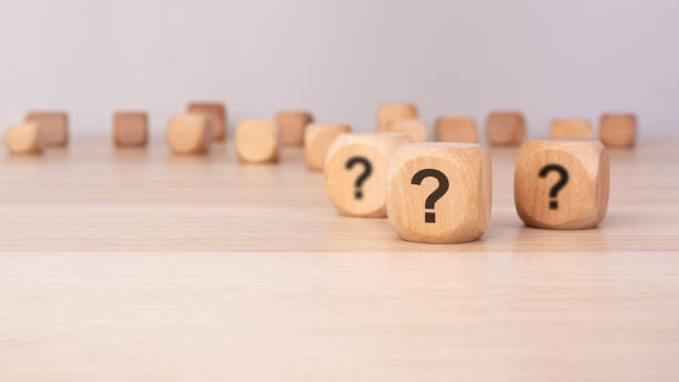 istock three wooden blocks with question marks over a gray background with copy space 2206137780