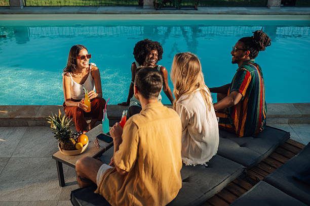 istock Friends enjoying drinks and conversation by the pool 2206139058